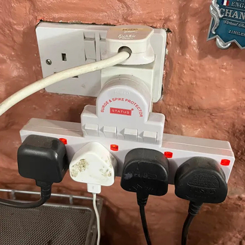 Two wall socket adapters with many plugs plugged into them